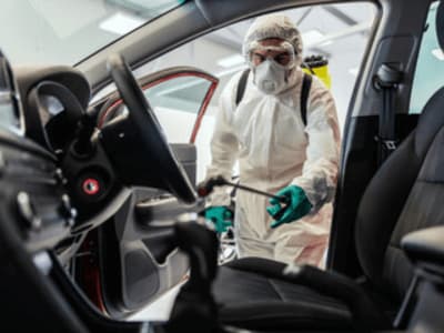 un addetto effettua una sanificazione auto